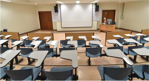 A classroom facing a large projector sreen